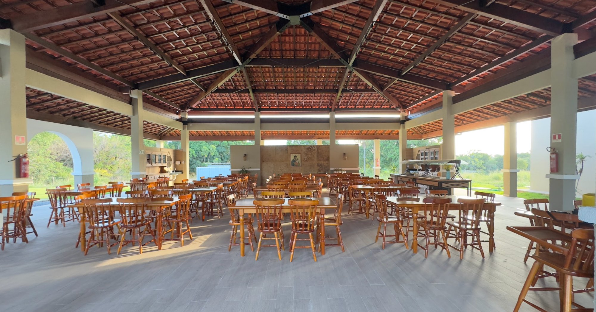 Área de refeições espaçosa com mesas de madeira